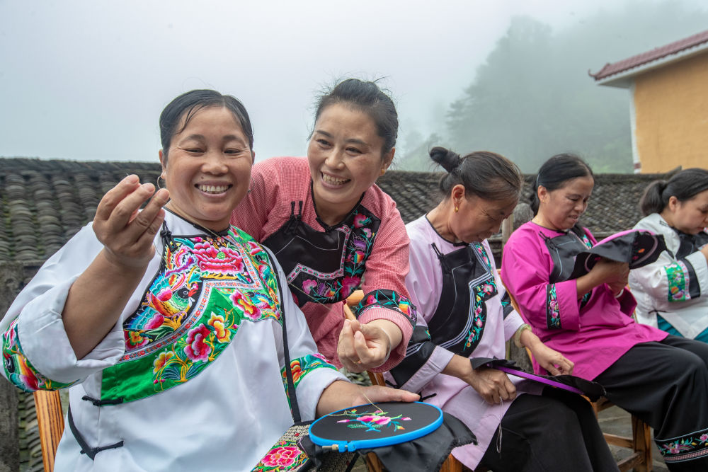 在湖南省湘西土家族苗族自治州花垣縣十八洞村，村民在討論苗繡制作（2020年7月16日攝）。